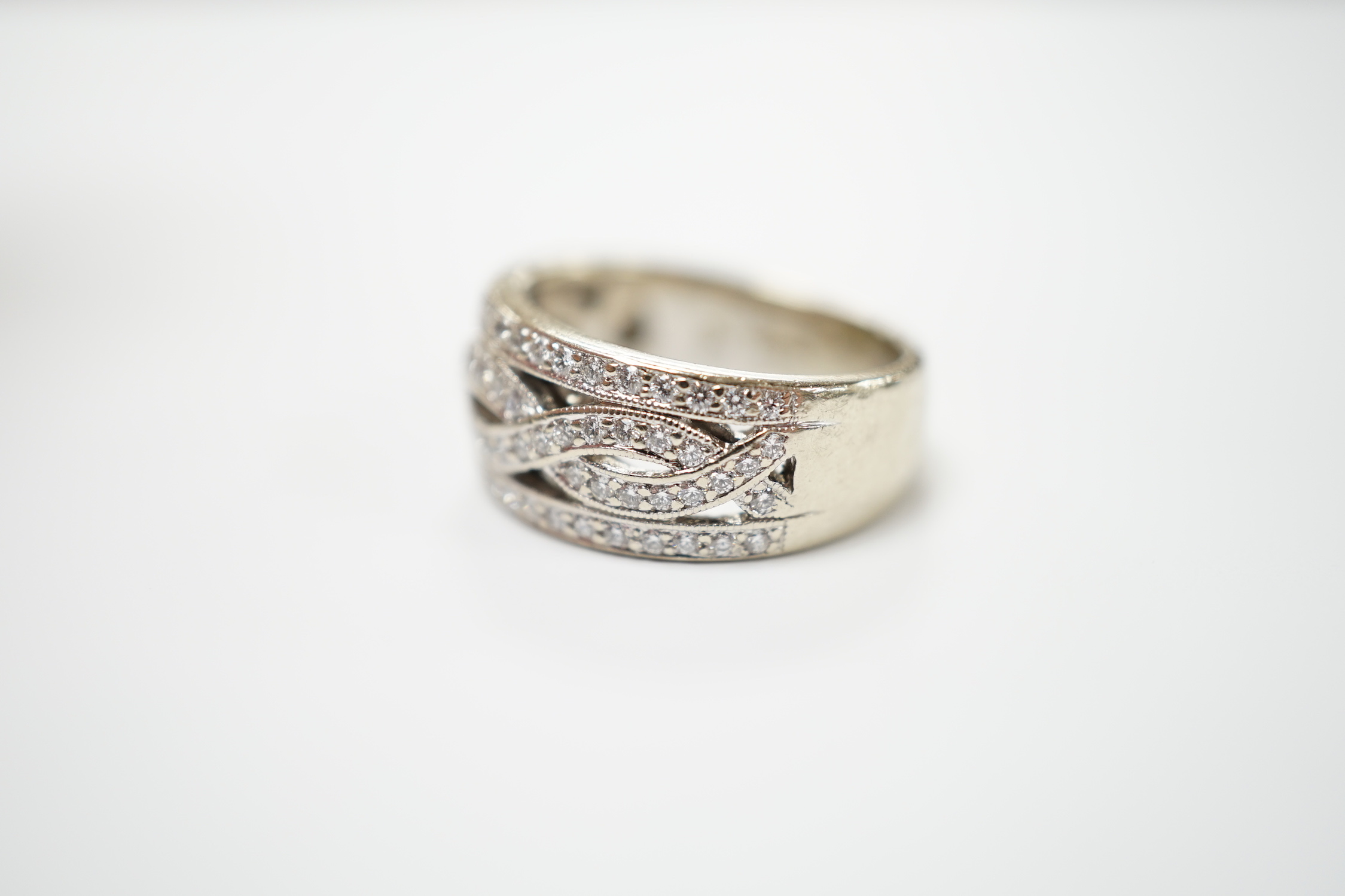 A modern 14ct gold and diamond chip set spiral band cluster half hoop ring, size L, gross weight 7.3 grams.
